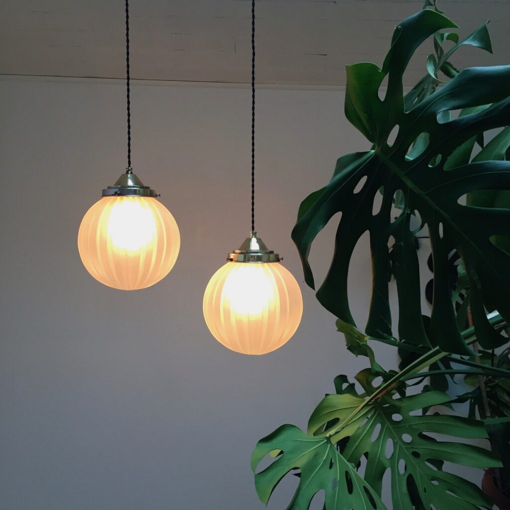 Paire-de-suspensions-boule-en-verre-sable-vue-allumee-plante_Maison_Liedekerke_maison-lk.jpeg